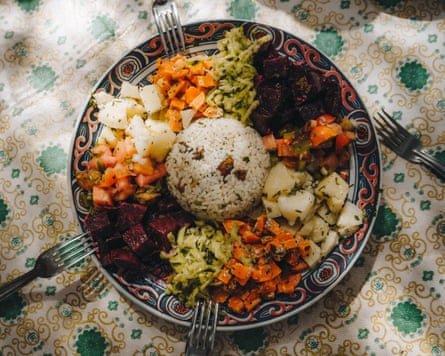 A colourful Moroccan vegan salad on a table made up of lettuce, broccoli, carrots and rice.