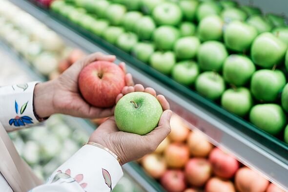 Close up of hand picking green and red apples on a market
